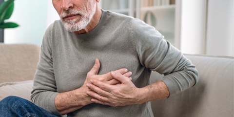 Photo of an unidentifiable man holding his chest.