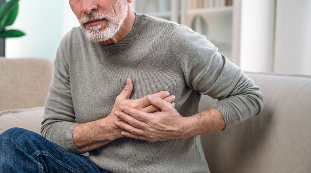 Photo of an unidentifiable man holding his chest.
