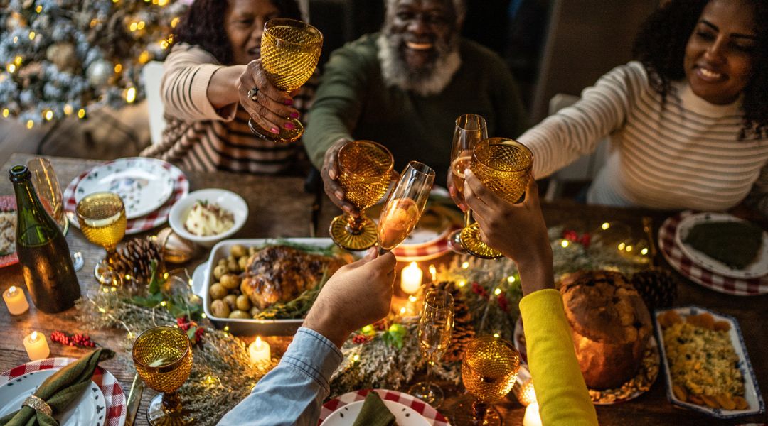 Family touching glasses over holiday table.